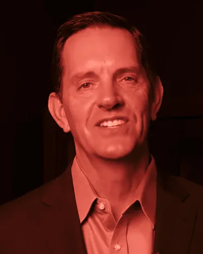 Frame from John David Crow’s 2026 campaign video: Crow mid-sentence, in a dark suit and blue shirt.