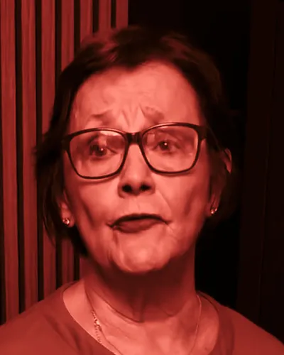 Frame from Susan Winder’s 2026 campaign video: Winder mid-sentence, in a green top and glasses.